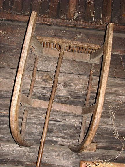 A wooden sledge and a rake stored in the basement shed at Kavčnik Homestead folk architecture museum