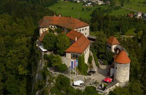 Aerial view of <!--LINK'" 0:74--> showing the layout of castle buildings around the upper and lower courtyards, connected with a staircase. The oldest part of the castle is the Romanesque entrance tower, other sections are Gothic and Renaissance styles.